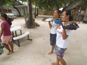 海鮮物を皿に持って売り歩くパンダン島の女性達