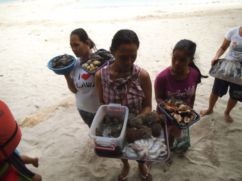 生きた海の幸を料理用に売り歩く島の女性たち