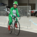 カエルの仮装をして自転車に乗る女性