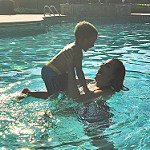 息子とプールで遊ぶお母さん
