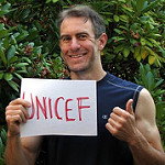 UNICEFと書かれた画用紙を掲げる白人男性