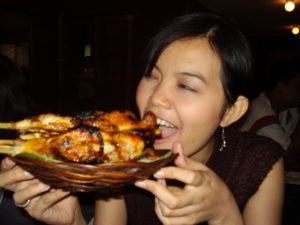 バコロドチキンをほおばるフィリピン女性